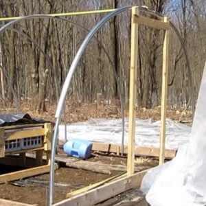 Attaching the wiggle wire to the pole of the hoop house