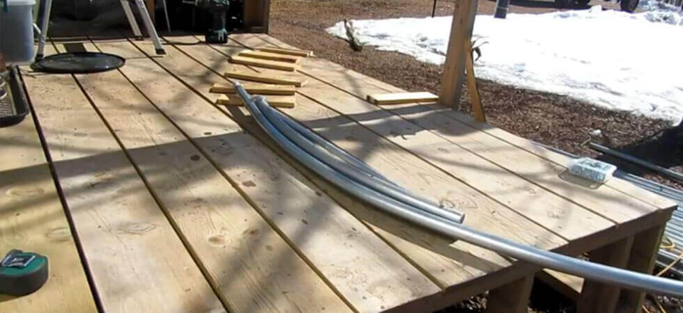 using a pole bender to  bend the hoop house poles